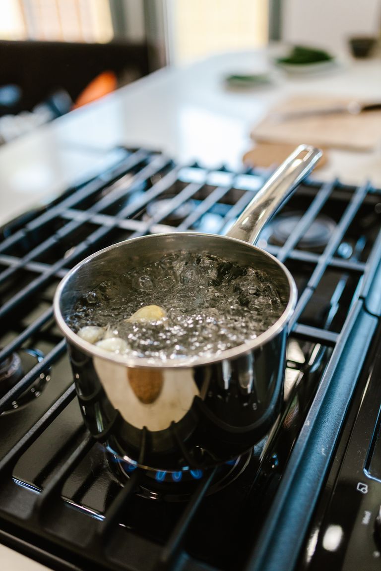 A pot of water boiling on a gas stove, capturing a culinary moment in a modern kitchen.