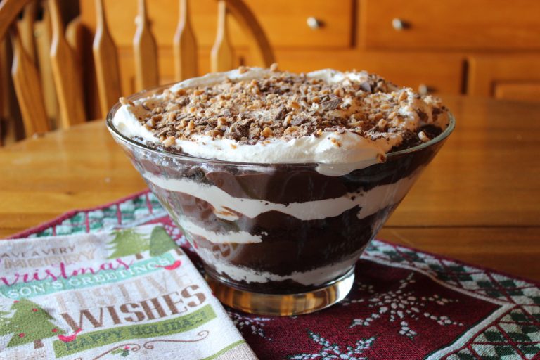 Chocolate Trifle in a glass bowl with layers of devils food cake, whipped topping, chocolate pudding and health toffee bits - The Hot Mess Kitchen