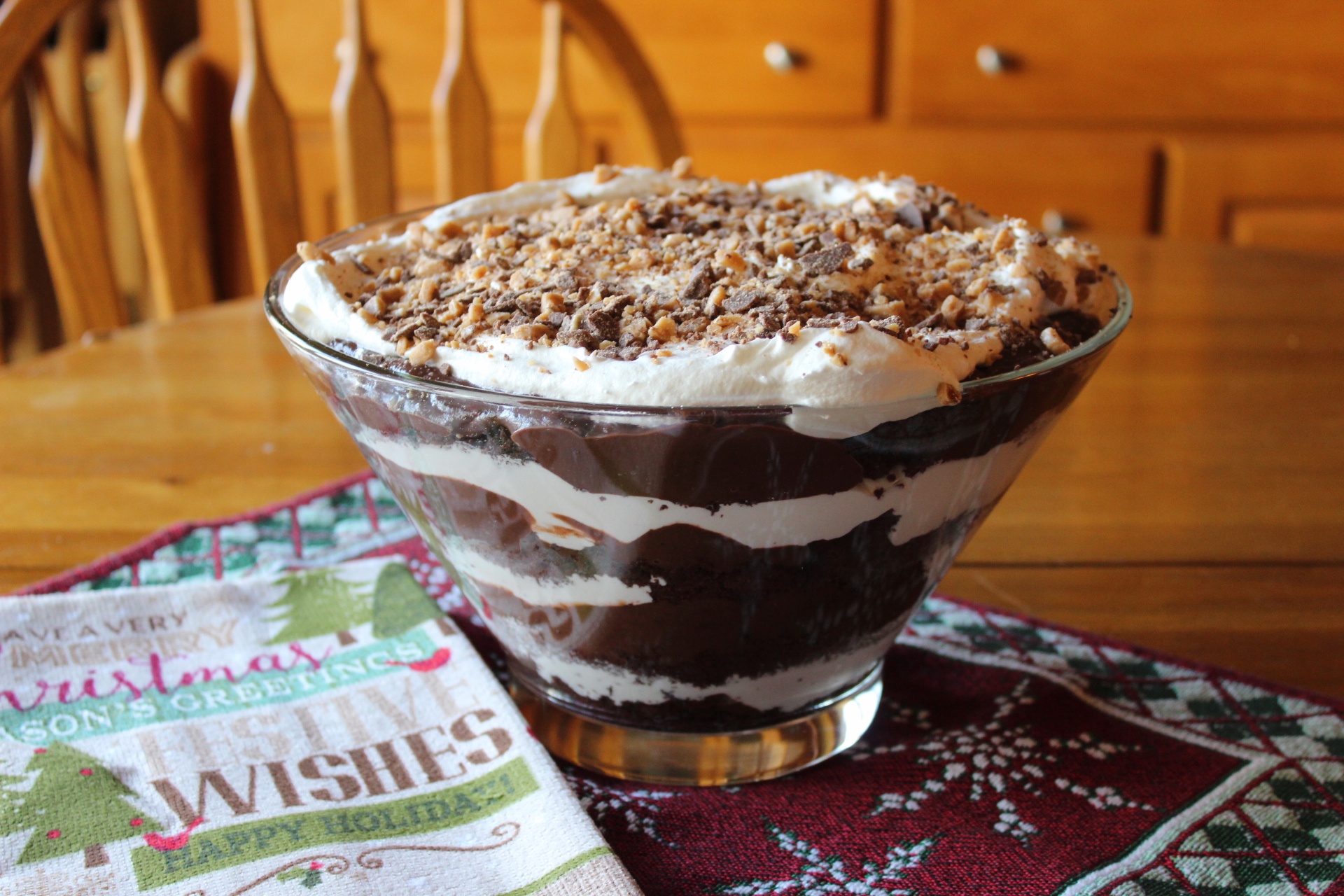 Chocolate Trifle in a glass bowl with layers of devils food cake, whipped topping, chocolate pudding and health toffee bits - The Hot Mess Kitchen
